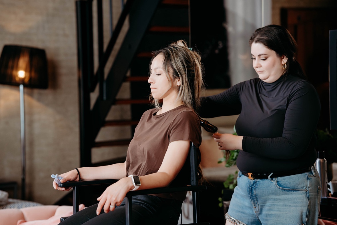 Adriana stylt het haar van een klant in een loft