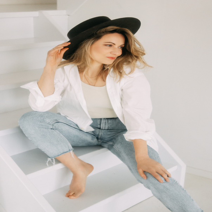 Model met hoed op een witte trap, brandingshoot